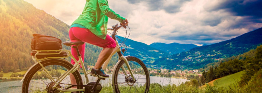 sportive woman with e-bike above a lake